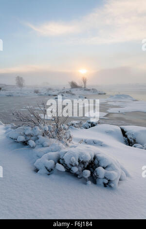 Die Sonne sticht durch den Nebel über Rannoch Moor über den Ufern des man Na Stainge, Schottland Stockfoto