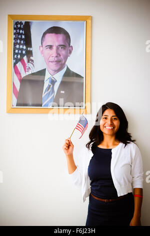 Patriotische Latina Frau Einbürgerung, ein US-Staatsbürger, neben einem Bild von Barrack Obama Stockfoto