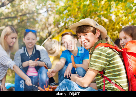 Freunde auf Campingplatz mit Würstchen Stöcke im Wald Stockfoto
