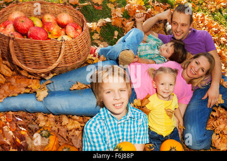 Familie Verlegung auf Rasen mit orange Herbst Blätter Stockfoto