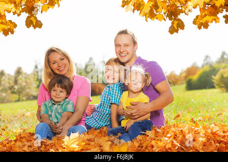 Porträt der glückliche Familie sitzen auf den Blättern Stockfoto