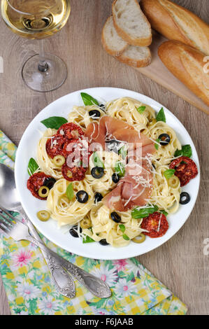 Nudeln mit Schinken, Oliven, getrockneten Tomaten und parmesan Stockfoto