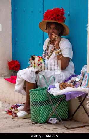 alten kubanischen Frau raucht auf der Straße eine kubanische Zigarre und Post mit ihrer Katze für die Touristen, Kuba, North America, Caribbean Stockfoto