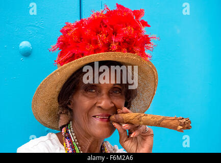 alten kubanischen Frau raucht auf der Straße eine kubanische Zigarre und Post mit ihrer Katze für die Touristen, Kuba, North America, Caribbean Stockfoto