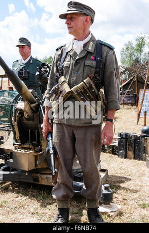 WW2re-enactment. Die deutsche Wehrmacht officer Standing im Kampf uniform, tragen M 38/40 Munition Beutel, und M43 Wollmütze. Holding sub Machine Gun. Stockfoto