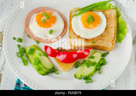 Spiegeleier mit frischem Gemüse für gesundes Frühstück. Glücklich lachendes Gesicht Stockfoto