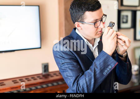 Juwelier Diamanten gründlich durch Lupe untersuchen Stockfoto