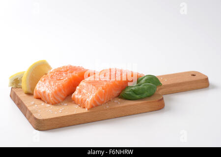 zwei gesalzenen Lachsfilets auf Holzbrett Stockfoto