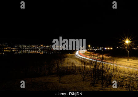 Pkw-Verkehr auf Winterdienst mit beleuchtete Brücke im Hintergrund Stockfoto