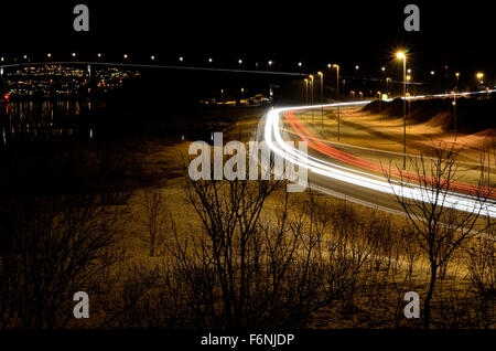 Pkw-Verkehr auf Winterdienst mit beleuchtete Brücke im Hintergrund Stockfoto