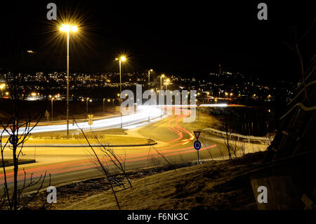 Pkw-Verkehr auf Straße in der Nacht um Kreisverkehr Stockfoto