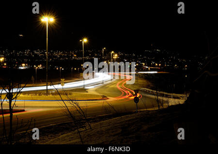 Pkw-Verkehr auf Straße in der Nacht um Kreisverkehr Stockfoto