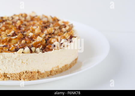 Hausgemachter Kokos Käsekuchen mit Karamell und verschiedenen Nüssen Stockfoto