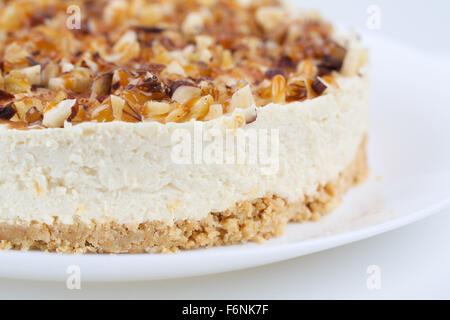 Hausgemachter Kokos Käsekuchen mit Karamell und verschiedenen Nüssen Stockfoto