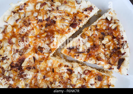 Hausgemachter Kokos Käsekuchen mit Karamell und verschiedenen Nüssen Stockfoto