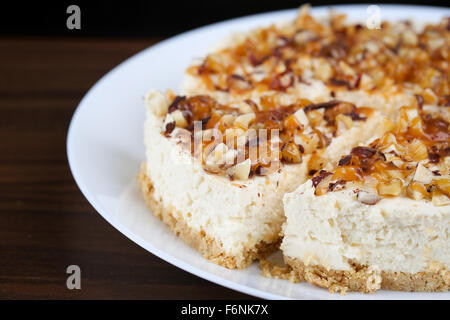 Hausgemachter Kokos Käsekuchen mit Karamell und verschiedenen Nüssen Stockfoto