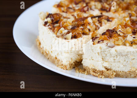 Hausgemachter Kokos Käsekuchen mit Karamell und verschiedenen Nüssen Stockfoto