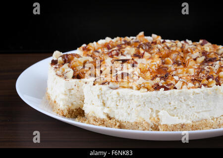 Hausgemachter Kokos Käsekuchen mit Karamell und verschiedenen Nüssen Stockfoto