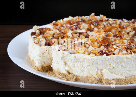 Hausgemachter Kokos Käsekuchen mit Karamell und verschiedenen Nüssen Stockfoto