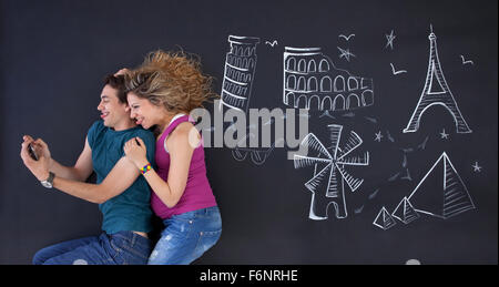 Junges Paar macht ein Selbstporträt mit Welt Attraktionen Buchdrucks hinter. Stockfoto