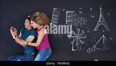 Junges Paar macht ein Selbstporträt mit Welt Attraktionen Buchdrucks hinter. Stockfoto