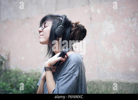 Teen Frau mit Kopfhörern hören Musik mit tiefen Emotionen Stockfoto