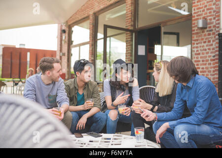 Gruppe junger multiethnischen Freunde sitzen in einer Bar einen Drink, reden miteinander, Spaß - Happy-Hour, Freundschaft, Stockfoto