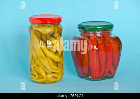 Gemüse-Paprika bewahrt in zwei Gläsern auf blauem Hintergrund Stockfoto