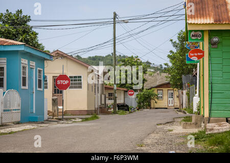 Vielzahl von Telefon und Strom Kabel Kreuz auf dem Dach Höhe zwischen den kleinen Geschäften und Häusern in Gros Islet, St. Lucia. Stockfoto