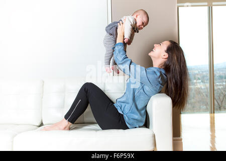 Mutter mit Baby auf dem Sofa, die gute Zeit nehmen Stockfoto