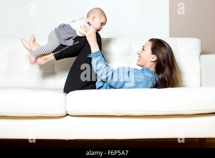 Mutter mit Baby auf dem Sofa, die gute Zeit nehmen Stockfoto