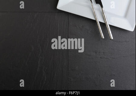 Draufsicht der weißen quadratischen Teller, Messer und Gabel. Stockfoto