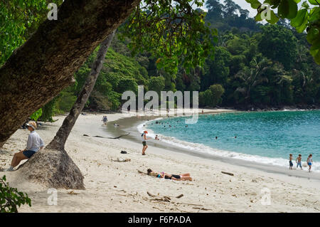 Touristen, Schwimmen und Sonnenbaden am Strand in Manuel Antonio Nationalpark, Costa Rica Stockfoto