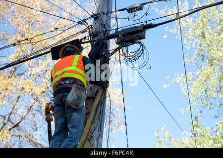 Kabel-Mann Upgrade Kabel am Telefon Strommast Schutzhelm und Warnweste tragen. St Paul Minnesota MN USA Stockfoto