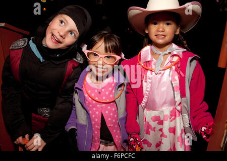 Asiatische und weiße amerikanische Kinder Trick oder behandelnden in Halloween-Kostümen. St Paul Minnesota MN USA Stockfoto