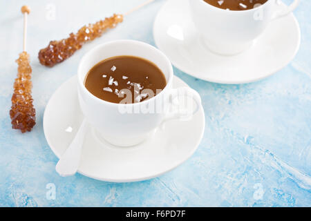 Karamell-Pudding in weißen Schalen mit Flocken Salz Stockfoto