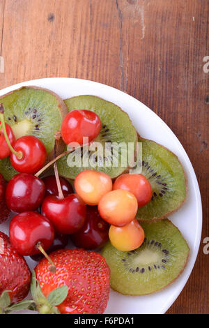 Gesundheit-Frucht mit Kirsche, Erdbeere, Kiwi auf Holzplatte Stockfoto