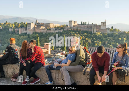 Touristen und paar küssen am Mirador San Nicolas in der Albaicin mit Alhambra im Hintergrund. Granada, Spanien Stockfoto