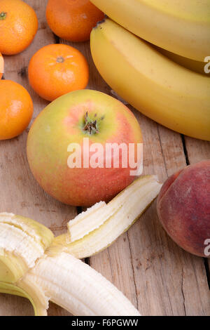 Bananen Apfel Mandarine Pfirsich auf hölzernen Hintergrund als Health Food Konzept Stockfoto