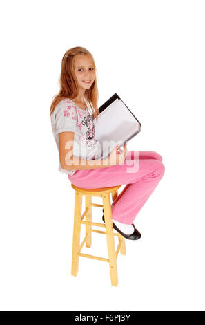 Eine junge Blondine in rosa Hose sitzen, halten Sie ihre Ordner und Blick in die Kamera, für weißen Hintergrund isoliert. Stockfoto