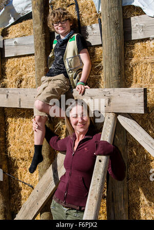 Attraktive Mutter und seinem kleinen Sohn posieren für Fotos von gestapelten Heuballen auf ranch Stockfoto