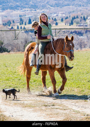 Attraktive Mutter und seinem kleinen Sohn Reiten auf der Ranch Weide Stockfoto