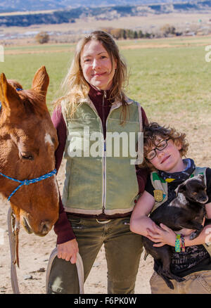 Attraktive Mutter; jungen Sohn; Pferd und Hund posieren außerhalb auf Ranch für ein Foto Stockfoto