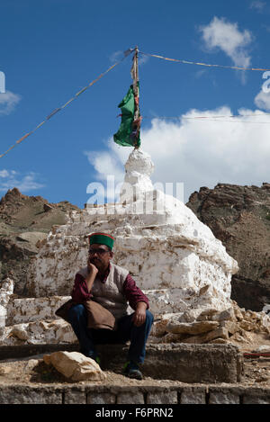 Indischen Mann in traditioneller Kleidung saß neben buddhistischen Stupa in der Himalaya-Region von Himachal Pradesh Stockfoto