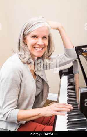 Kaukasische Frau spielt Klavier Stockfoto