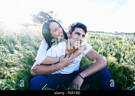 Paar sitzt im Feld Stockfoto