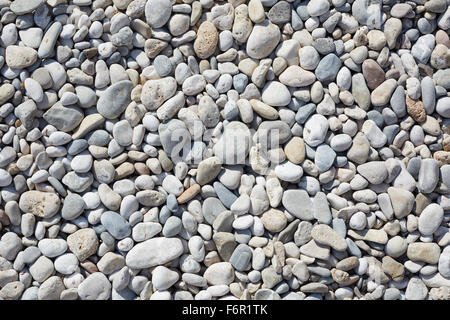 Kieselsteine am Strand, abstrakte Stein Hintergrund mit direkter Sonneneinstrahlung Stockfoto