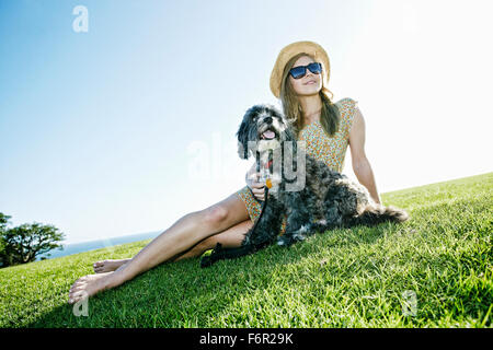 Kaukasische Frau im Feld mit Hund Stockfoto