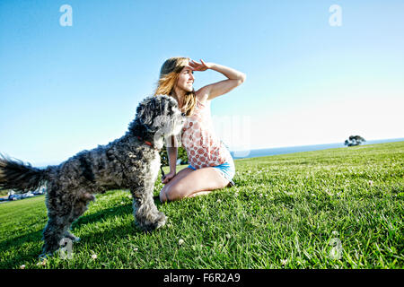 Kaukasische Frau im Feld mit Hund Stockfoto