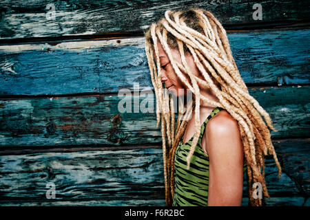 Schwarze Frau mit Dreadlocks an Holzwand Stockfoto